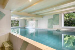a swimming pool in a house with blue tiles at Haus Schöneck in Otterndorf
