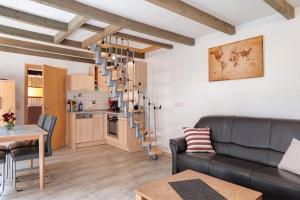 a living room with a couch and a spiral staircase at Haus Schöneck in Otterndorf