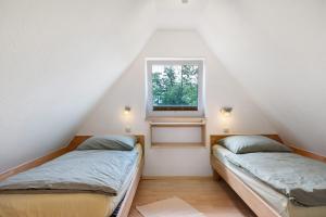 two beds in a room with a window at Haus Schöneck in Otterndorf +17 photos