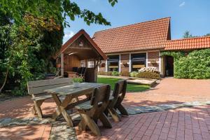 a wooden picnic table and bench in front of a house at Haus Schöneck in Otterndorf