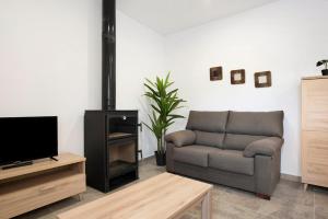 a living room with a couch and a television at Villa Montenmedio - Paula in El Soto