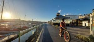 a boy riding a bike on a boardwalk near a marina at Morada Ribes in Costa de Antigua