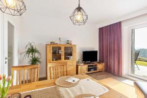 a living room with a table and a tv at Fewo Auszeit zum Anspel in Medebach