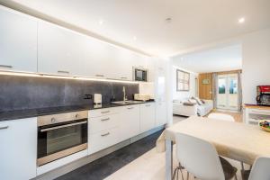 a kitchen with white cabinets and a dining table at Lagomar in Alcudia