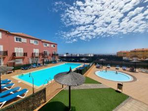a large swimming pool with chairs and an umbrella at Morada Ribes in Costa de Antigua