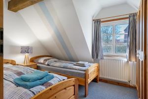 a bedroom with two beds and a window at Haus Möwe und Robbe in Dagebüll