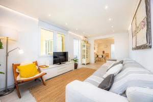 a living room with a white couch and a tv at Lagomar in Alcudia