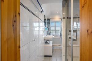 a white bathroom with a sink and a mirror at Haus Möwe und Robbe in Dagebüll +42 photos