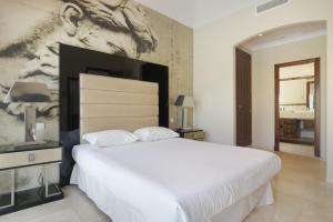 a bedroom with a large white bed and a painting on the wall at Luxury Villa Arcos Golf in Arcos de la Frontera +21 photos