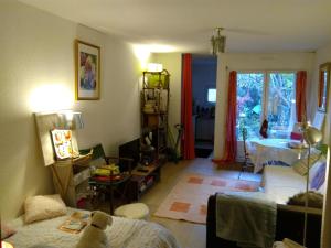 Una sala de estar con una cama y una ventana. en Joli studio avec jardinet, en Aviñón