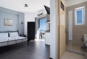 una camera da letto con un letto e un bagno con un tavolo di Iguana studio 3 a Preveza