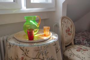 a green vase sitting on a table with two candles at Attico Palazzo Giustiniani in Genoa +23 photos