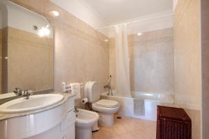 a bathroom with a sink and a toilet and a tub at Glamorous Villa T3 Praia Verde in Castro Marim +20 photos