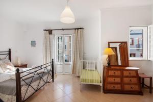 a bedroom with a bed and a dresser and a mirror at Glamorous Villa T3 Praia Verde in Castro Marim