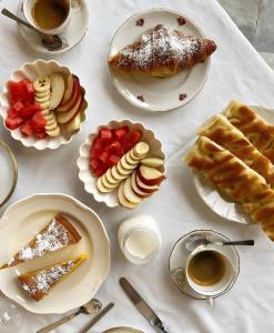 a table with plates of food and cups of coffee at Attico Palazzo Giustiniani in Genoa