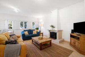 a living room with a couch and a tv at Glamorous Villa T3 Praia Verde in Castro Marim