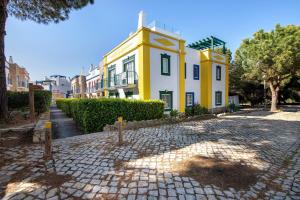 a yellow and white building on a cobblestone street at Glamorous Villa T3 Praia Verde in Castro Marim