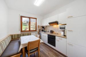 a kitchen with white cabinets and a table with a tableablish at Pension Schneider in Freiamt