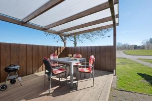 a pergola on a deck with a table and chairs at Haus Möwe und Robbe in Dagebüll