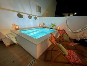 a large swimming pool in a room with a hammock at Casa River Sun in Valada