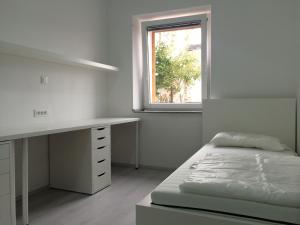 una camera con letto, scrivania e finestra di Apartments Šik 2 a Capodistria