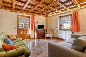 a living room with two couches and a tv at Baita Del Canton in Valdidentro