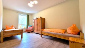 a bedroom with a bed with orange pillows at Gittas Paradiesperle in Niederdreisbach +28 photos