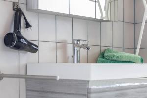 a bathroom sink with a mirror and a green towel at Ferienwohnung Frank in Melschede +16 photos