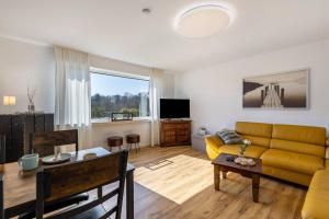a living room with a yellow couch and a table at Ferienwohnung Frank in Melschede