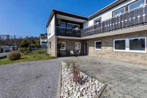 a brick house with a balcony on top of it at Ferienwohnung Frank in Melschede