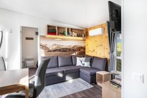 a living room with a couch and a table at Side-by-Side Tiny Houses in Untergriesbach