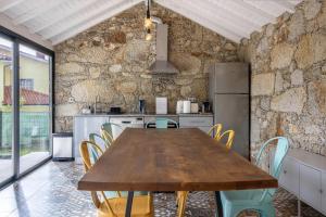 a kitchen with a wooden table and chairs at Casa do Mestre Studio e Suíte Extra in Vila de Punhe