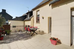 a patio with a table and chairs on a balcony at Chambre d'hote Reine in Cancale