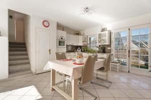a white kitchen with a table and chairs and a staircase at Chambre d'hote Reine in Cancale
