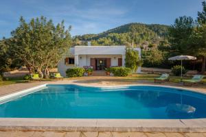 a villa with a swimming pool in front of a house at Can Ramon 1 in Sant Josep de sa Talaia