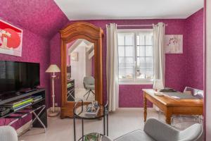a living room with purple walls and a mirror at Chambre d'hôtes - Mon Plaisir in Civray-de-Touraine