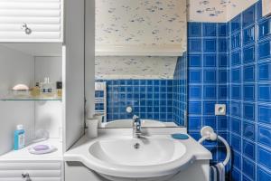 a bathroom with a white sink and blue tiles at Chambre d'hôtes - Mon Plaisir in Civray-de-Touraine +17 photos