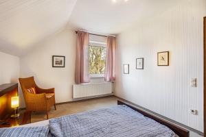 a bedroom with a bed and a chair and a window at Ferienwohnung Grothoff in Olsberg
