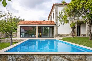 a pool in the backyard of a home with a house at Casa do Mestre Studio e Suíte Extra in Vila de Punhe