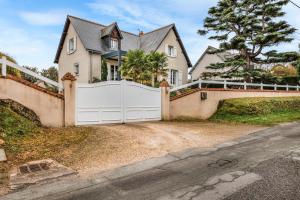 a house with a white gate on a driveway at Chambre d'hôtes - Mon Plaisir in Civray-de-Touraine