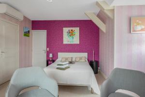 a bedroom with a white bed and two chairs at Chambre d'hôtes - Mon Plaisir in Civray-de-Touraine