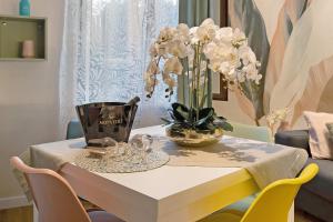 a table with a vase of white flowers on it at Soleluna in Vado Ligure