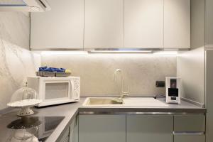 a kitchen with a sink and a microwave at Soleluna in Vado Ligure +7 photos
