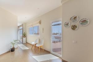 a living room with white walls and a table and chairs at Ático San Miguel vacacional in Gáldar