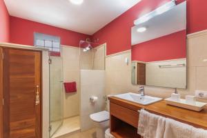 a bathroom with red walls and a sink and a shower at Ático San Miguel vacacional in Gáldar +23 photos