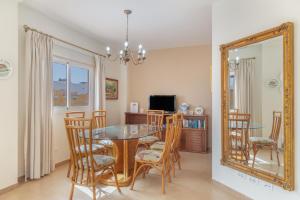 a dining room with a table and chairs and a mirror at Ático San Miguel vacacional in Gáldar