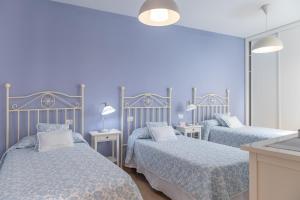 a blue bedroom with two beds and a mirror at Ático San Miguel vacacional in Gáldar