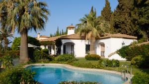 a villa with a swimming pool in front of a house at Villa Tropical Dream in Salobreña