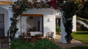 a patio with chairs and a table with flowers at Villa Tropical Dream in Salobreña