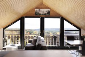 a living room with a couch and large windows at Bergliebe in Bitz